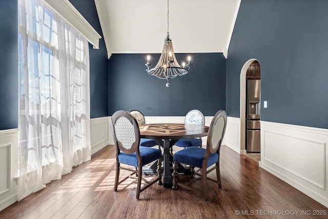 7185 N 194th E Ave, Owasso, OK 74055 - dining room featuring arched walkways, wainscoting, a chandelier, wood finished floors, and high vaulted ceiling