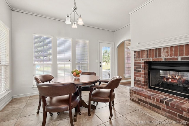 7185 N 194th E Ave, Owasso, OK 74055 - dining room with ornamental molding, light tile patterned floors, a fireplace, a chandelier, and arched walkways
