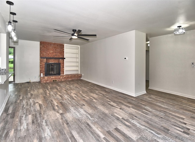 5701 S Rockford Pl, Tulsa, OK 74105 - unfurnished living room featuring wood finished floors, ceiling fan, built in features, and a brick fireplace