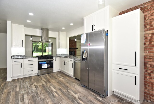 5701 S Rockford Pl, Tulsa, OK 74105 - kitchen with appliances with stainless steel finishes, island exhaust hood, brick wall, dark wood-style flooring, and white cabinets
