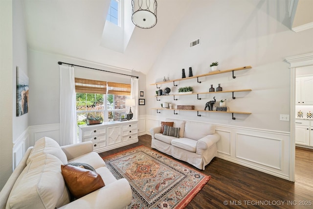 14003 E 87th Pl N, Owasso, OK 74055 - living room featuring wood finished floors, a skylight, high vaulted ceiling, wainscoting, and a decorative wall
