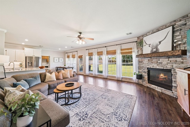 14003 E 87th Pl N, Owasso, OK 74055 - living area with ceiling fan, dark wood-style floors, a stone fireplace, ornamental molding, and recessed lighting