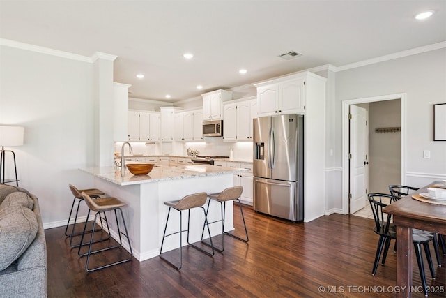 14003 E 87th Pl N, Owasso, OK 74055 - kitchen featuring stainless steel appliances, a kitchen bar, crown molding, a peninsula, and white cabinets