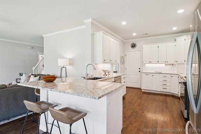 14003 E 87th Pl N, Owasso, OK 74055 - kitchen featuring a peninsula, appliances with stainless steel finishes, crown molding, white cabinets, and a breakfast bar area