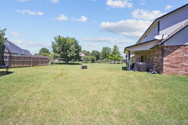 14003 E 87th Pl N, Owasso, OK 74055 - fenced backyard featuring a trampoline and a fire pit