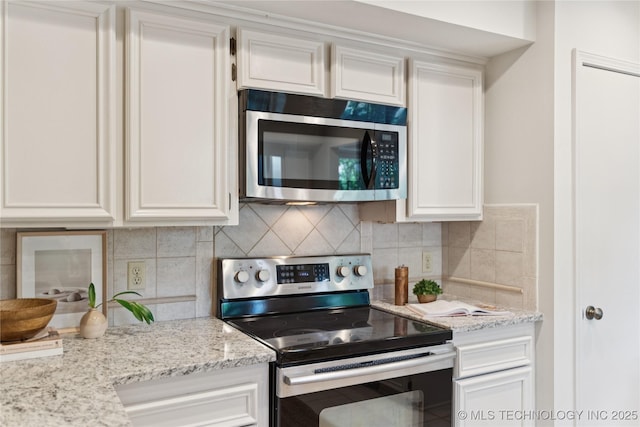 8912 S 70th E Ave, Tulsa, OK 74133 - kitchen with appliances with stainless steel finishes, tasteful backsplash, white cabinets, and light stone countertops