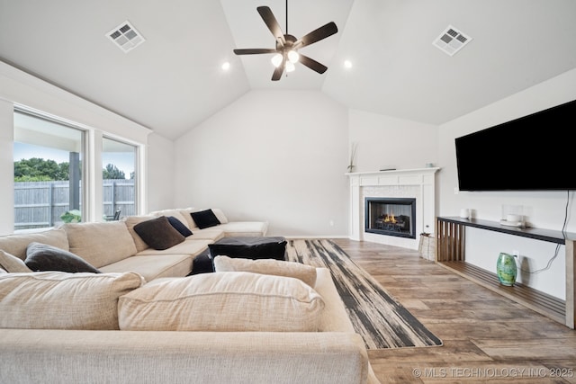 7413 N 160th E Ave, Owasso, OK 74055 - living room with wood finished floors, a ceiling fan, vaulted ceiling, a lit fireplace, and recessed lighting