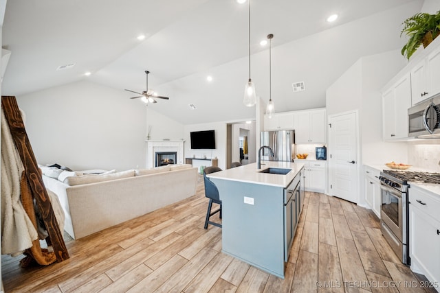 7413 N 160th E Ave, Owasso, OK 74055 - kitchen featuring appliances with stainless steel finishes, white cabinetry, light countertops, light wood-style flooring, and ceiling fan