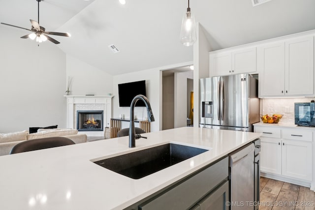 7413 N 160th E Ave, Owasso, OK 74055 - kitchen featuring stainless steel appliances, open floor plan, lofted ceiling, light countertops, and tasteful backsplash