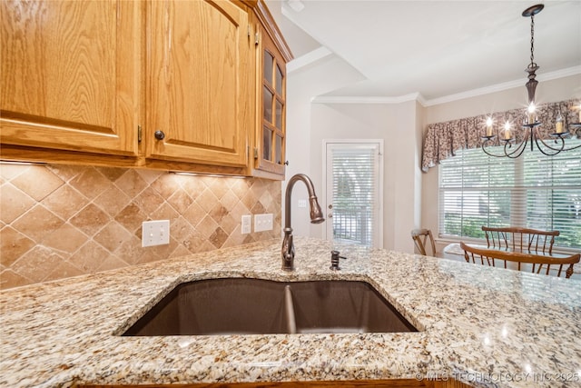 7534 S Hudson Pl, Tulsa, OK 74136 - kitchen featuring light stone counters, a chandelier, backsplash, pendant lighting, and ornamental molding