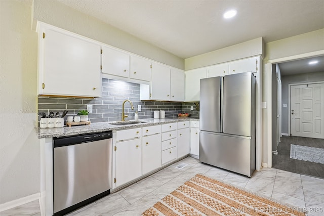 3350 E 54th St, Tulsa, OK 74135 - kitchen featuring appliances with stainless steel finishes, decorative backsplash, light stone countertops, white cabinetry, and light marble finish floors