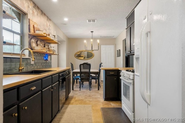 22 Mary St, Kiefer, OK 74041 - kitchen with white appliances, open shelves, dark cabinets, a chandelier, and hanging light fixtures