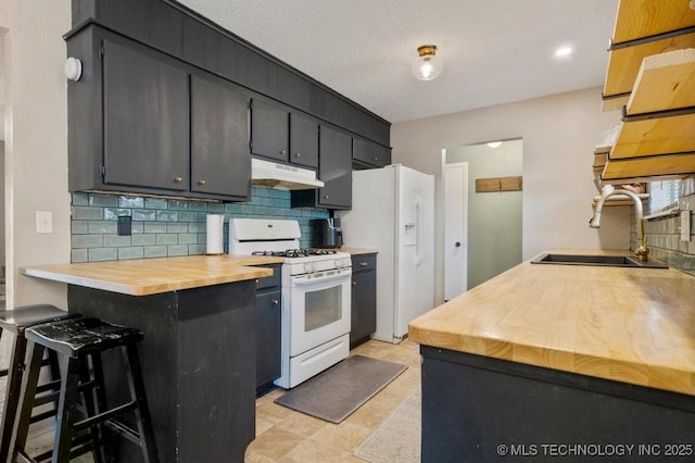 22 Mary St, Kiefer, OK 74041 - kitchen featuring white appliances, under cabinet range hood, butcher block countertops, backsplash, and a breakfast bar