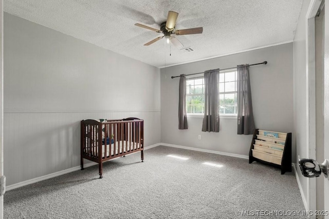 22 Mary St, Kiefer, OK 74041 - bedroom featuring a textured ceiling, carpet floors, a crib, ceiling fan, and wainscoting