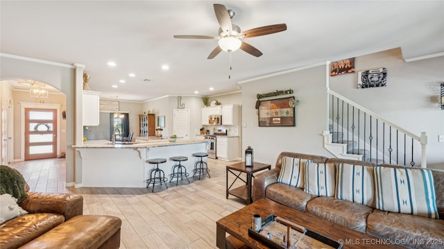 21820 Summit Trl, Claremore, OK 74019 - living room with ornamental molding, ceiling fan, arched walkways, light wood-type flooring, and recessed lighting