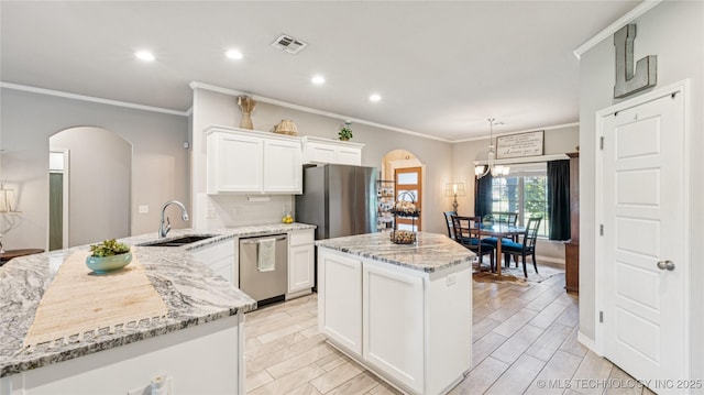 21820 Summit Trl, Claremore, OK 74019 - kitchen with arched walkways, appliances with stainless steel finishes, a center island, crown molding, and recessed lighting