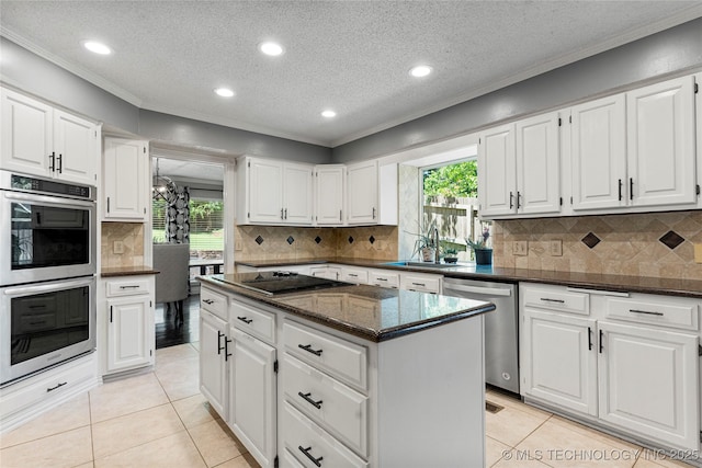 9622 S Maplewood Ave, Tulsa, OK 74137 - kitchen featuring appliances with stainless steel finishes, ornamental molding, light tile patterned floors, a textured ceiling, and a center island