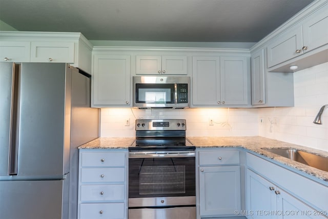 104 Gardenia Pl, Mannford, OK 74044 - kitchen with appliances with stainless steel finishes, tasteful backsplash, and light stone counters