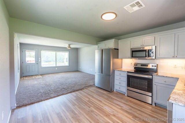 104 Gardenia Pl, Mannford, OK 74044 - kitchen with stainless steel appliances, light wood-type flooring, open floor plan, backsplash, and a ceiling fan