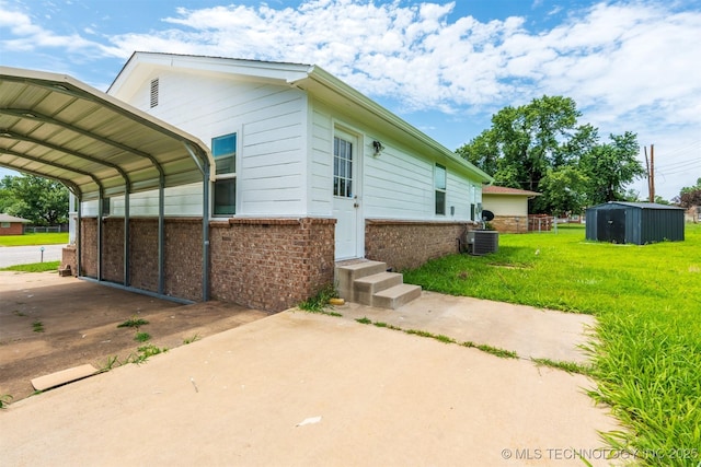 104 Gardenia Pl, Mannford, OK 74044 - view of side of home featuring brick siding, a detached carport, driveway, and a lawn