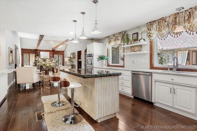 4335 E 87th St, Tulsa, OK 74137 - kitchen with stainless steel appliances, dark wood finished floors, a center island, white cabinets, and decorative light fixtures