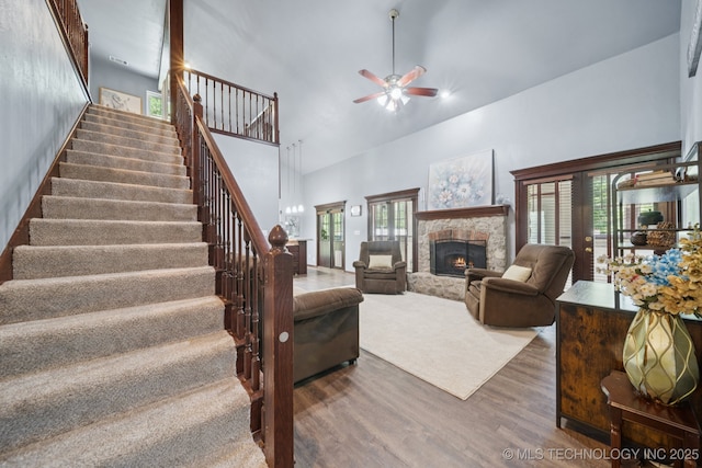 10102 N 147th E Ave, Owasso, OK 74055 - living room featuring wood finished floors, high vaulted ceiling, stairs, a ceiling fan, and a fireplace