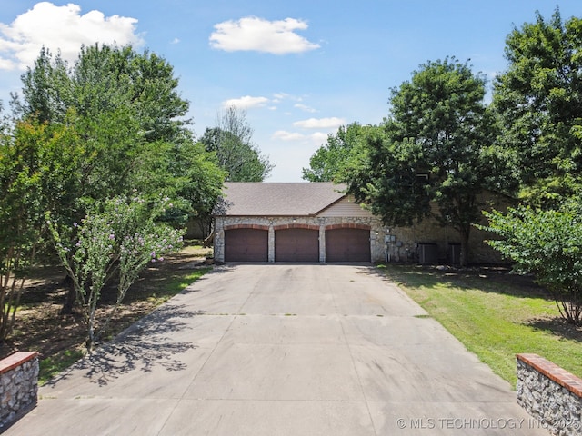 10102 N 147th E Ave, Owasso, OK 74055 - view of property hidden behind natural elements featuring stone siding and a front yard