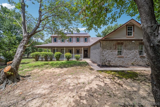 10102 N 147th E Ave, Owasso, OK 74055 - view of front facade featuring covered porch, solar panels, and stone siding