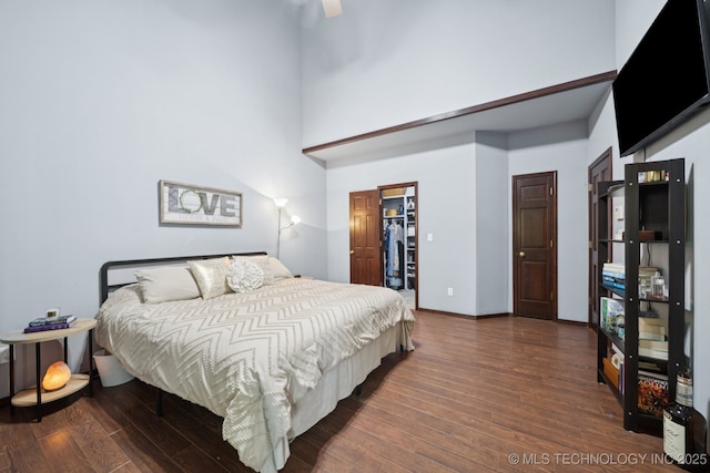 10102 N 147th E Ave, Owasso, OK 74055 - bedroom with wood finished floors, a towering ceiling, a walk in closet, and ceiling fan