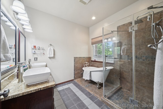 10102 N 147th E Ave, Owasso, OK 74055 - bathroom featuring double vanity, tile patterned floors, a freestanding tub, a stall shower, and recessed lighting