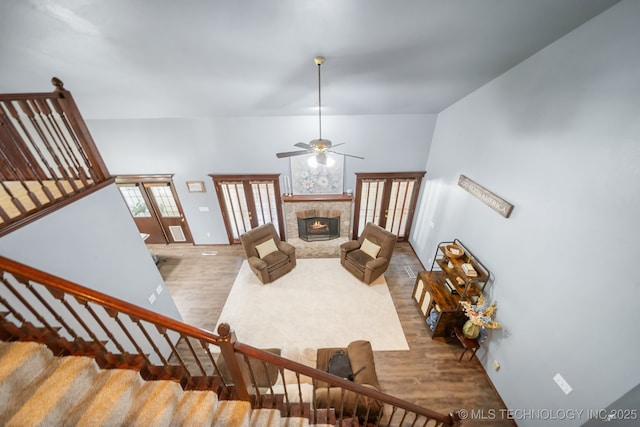 10102 N 147th E Ave, Owasso, OK 74055 - living area with wood finished floors, a lit fireplace, stairway, and a ceiling fan
