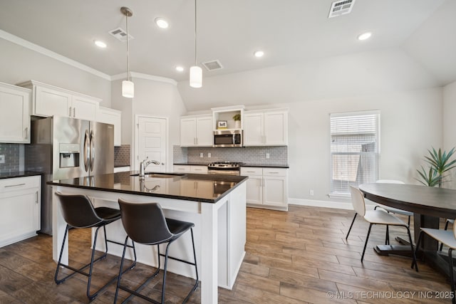 2618 W 115th St S, Jenks, OK 74037 - kitchen featuring stainless steel appliances, dark countertops, lofted ceiling, wood finished floors, and white cabinetry