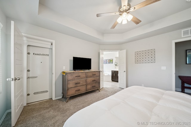 2618 W 115th St S, Jenks, OK 74037 - bedroom with light colored carpet, connected bathroom, a tray ceiling, and a ceiling fan