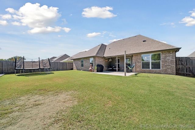 2618 W 115th St S, Jenks, OK 74037 - rear view of house with a trampoline, brick siding, a patio area, a fenced backyard, and roof with shingles