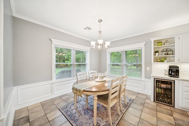 4852 E Redbud Dr, Claremore, OK 74019 - dining area featuring beverage cooler, a chandelier, a decorative wall, crown molding, and a wainscoted wall