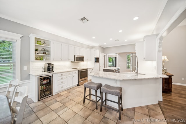 4852 E Redbud Dr, Claremore, OK 74019 - kitchen with wine cooler, stainless steel appliances, open shelves, crown molding, and white cabinets