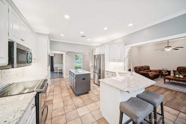 4852 E Redbud Dr, Claremore, OK 74019 - kitchen featuring appliances with stainless steel finishes, decorative backsplash, open floor plan, recessed lighting, and white cabinetry