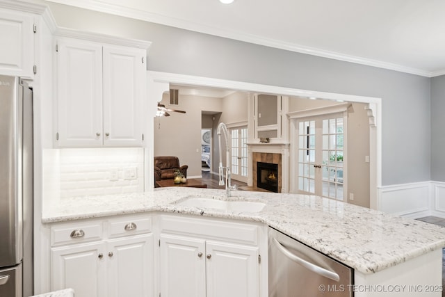 4852 E Redbud Dr, Claremore, OK 74019 - kitchen featuring stainless steel appliances, a ceiling fan, light stone countertops, white cabinets, and ornamental molding