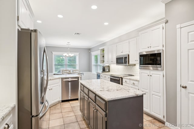 4852 E Redbud Dr, Claremore, OK 74019 - kitchen featuring appliances with stainless steel finishes, white cabinets, tasteful backsplash, crown molding, and a kitchen island