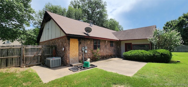 9712 S Hudson Ave, Tulsa, OK 74137 - rear view of house with stone siding, a patio area, a gate, roof with shingles, and board and batten siding