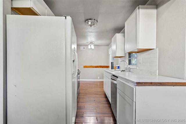 6264 E Latimer St, Tulsa, OK 74115 - kitchen with white refrigerator with ice dispenser, dark wood-style floors, white cabinets, dishwasher, and backsplash