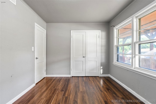 6264 E Latimer St, Tulsa, OK 74115 - unfurnished bedroom featuring dark wood-type flooring, ornamental molding, and a closet