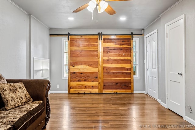 6264 E Latimer St, Tulsa, OK 74115 - living area featuring a ceiling fan, crown molding, wood finished floors, and a barn door