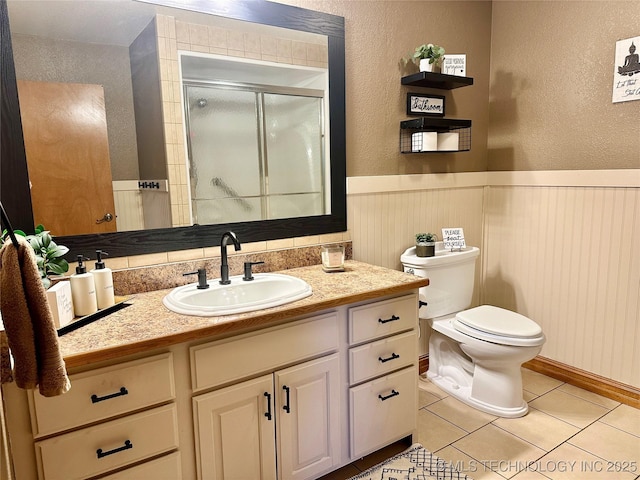 215 Belt St, Eufaula, OK 74432 - full bathroom featuring vanity, a stall shower, tile patterned floors, a textured wall, and wainscoting