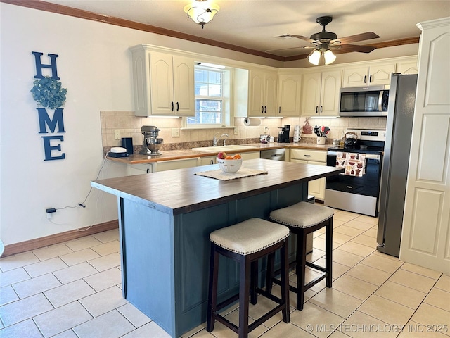 215 Belt St, Eufaula, OK 74432 - kitchen with appliances with stainless steel finishes, butcher block countertops, light tile patterned floors, tasteful backsplash, and crown molding