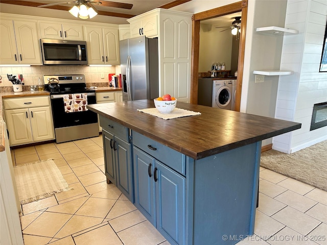 215 Belt St, Eufaula, OK 74432 - kitchen with wooden counters, stainless steel appliances, a ceiling fan, washer / dryer, and light tile patterned floors