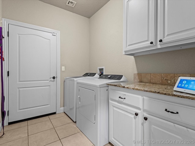 5719 Nottingham Pl, Bartlesville, OK 74006 - laundry room with independent washer and dryer, cabinet space, light tile patterned floors, and a textured ceiling