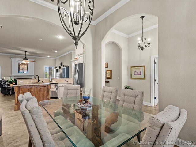 5719 Nottingham Pl, Bartlesville, OK 74006 - dining area featuring a chandelier, arched walkways, ornamental molding, and recessed lighting