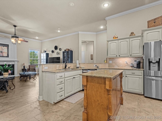 5719 Nottingham Pl, Bartlesville, OK 74006 - kitchen featuring stainless steel appliances, a kitchen island, crown molding, ceiling fan, and light stone counters