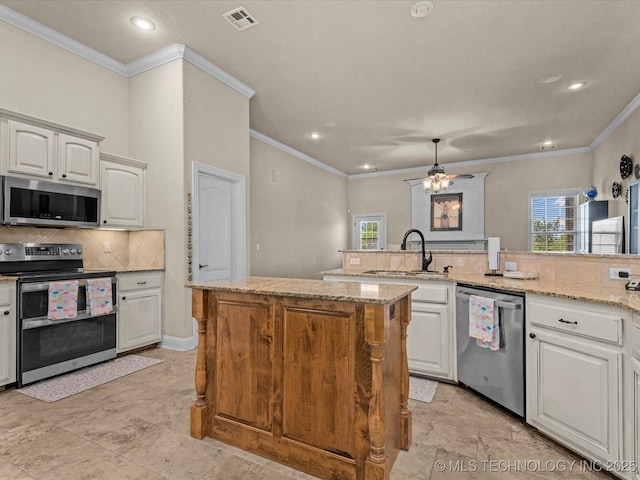 5719 Nottingham Pl, Bartlesville, OK 74006 - kitchen with appliances with stainless steel finishes, tasteful backsplash, a ceiling fan, recessed lighting, and a kitchen island